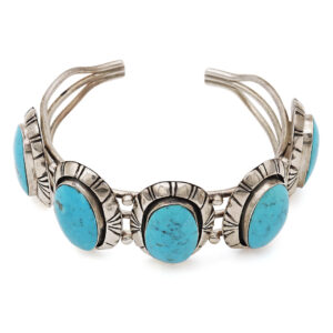 Vintage Navajo sterling silver turquoise cuff bracelet with multiple large oval turquoise stones on white background, showcasing intricate stamped design and traditional Southwestern craftsmanship.